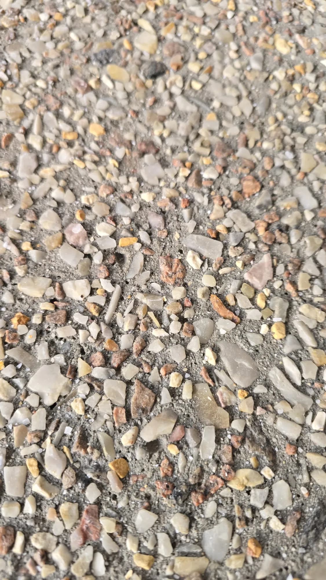 Close up of rough exposed aggregate before honing, showing sharp uncut stone tops